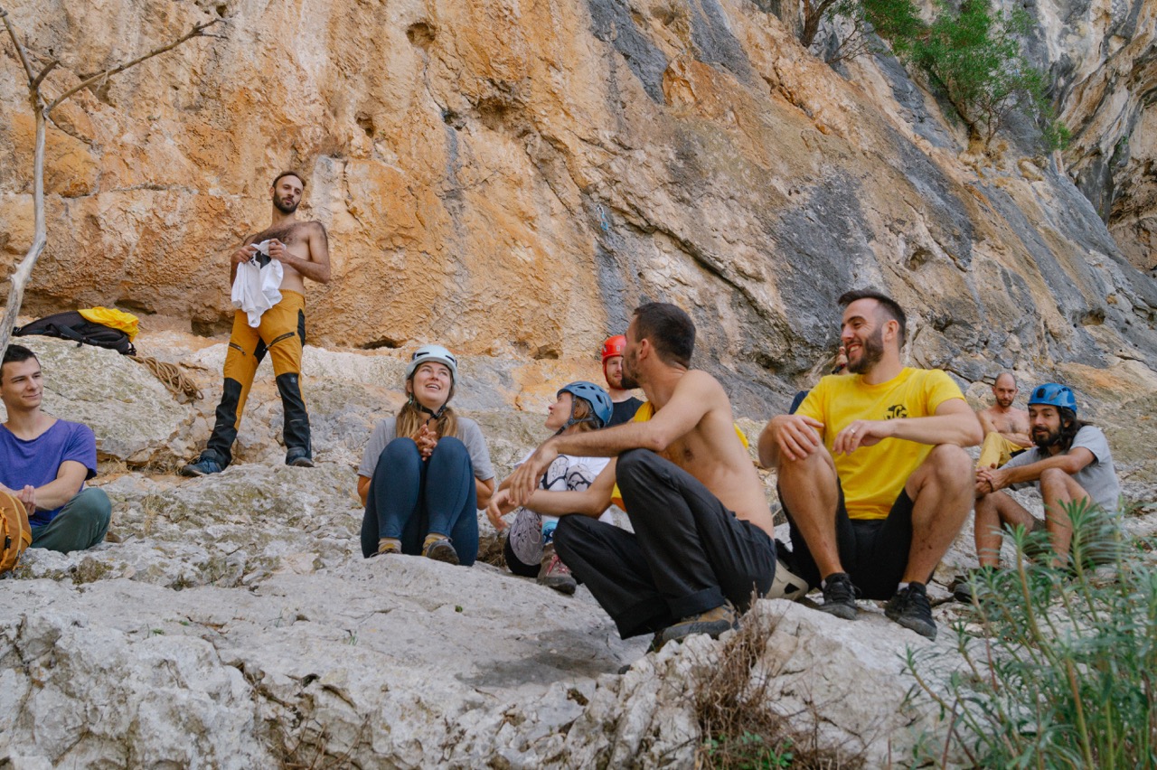 Climbers resting and chatting at the base of the crag